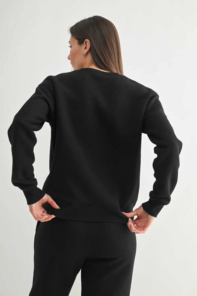 Person wearing a black sweatshirt and pants on a light gray backgroun