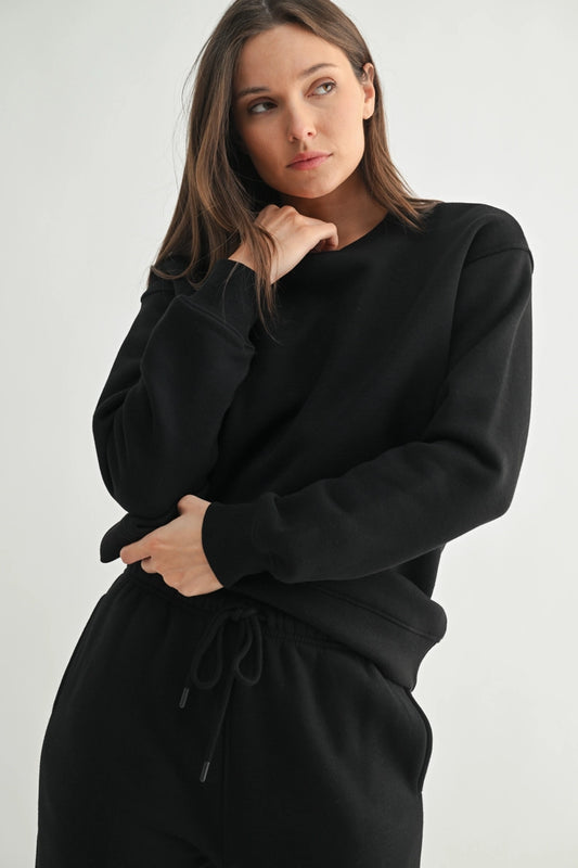 Woman wearing a black outfit against a plain background from RIODECA